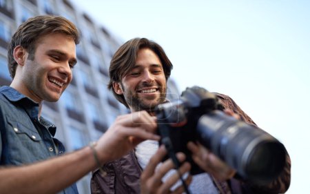 Téléchargez les photos : Hommes, amis et photographe avec appareil photo numérique dans les villes, les rues et la ville avec des médias pour portefeuille à Londres. Collaboration, créativité et photographie en ville pour construire le profil du projet - en image libre de droit