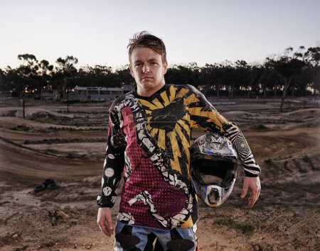 Photo for Man, portrait and dessert of professional motorcyclist or dirt bike racer with helmet in confidence for extreme sports. Confident male person, expert or rally rider in dunes for outdoor competition. - Royalty Free Image