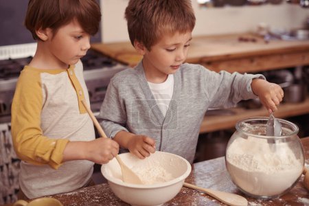 Foto de Niños, horneando y creativos en cocina con harina y medida de ingredientes secos en tazón para tarta. Niños, vinculación y desorden para las cookies en el hogar, el amor y la receta de pastelería para el aprendizaje de vacaciones. - Imagen libre de derechos