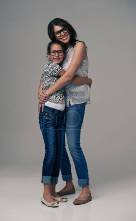 Photo for Happy mother, portrait and hugging child with love for care or support in fashion on a gray studio background. Mom, daughter or kid with smile in happiness for parenting or bonding on mockup space. - Royalty Free Image