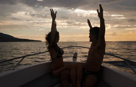 Téléchargez les photos : Couple, liberté et coucher de soleil sur bateau avec silhouette, heureux des vacances et Voyage en Italie pour l'océan et l'air frais. Aventure romantique pour l'amour, collage et excité avec les bras levés dans le transport. - en image libre de droit