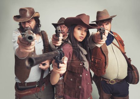 Banditengruppe, Porträt und Cowboys mit Waffe, zielen und Halloween auf weißem Hintergrund. Wilder Western, Kostüme und Charaktere von Texas Verbrechern, Comic und Vintage für Old West Thema mit Studio-Pistole.