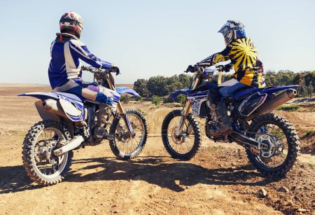 Photo for Rear view, sport or racer on motorcycle outdoor on dirt road with relax after driving, challenge or competition. Motocross, motorbike or dirtbike driver and helmet on offroad course or path at rally. - Royalty Free Image