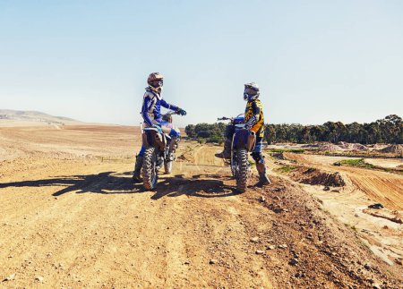 Photo for Sport, racer or relax on motorcycle outdoor on dirt road with blue sky for driving, challenge or competition. Gear, motorbike or dirtbike driver with helmet on offroad course or path for racing. - Royalty Free Image