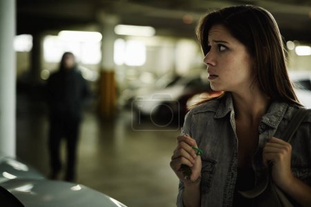 Photo for Female person, suspicious and parking lot with anxiety, worried and stressed for safety and concern. Woman, in danger and scared with backpack, terror and afraid for scary place and living in fear. - Royalty Free Image