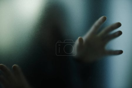 Foto de Miedo, misterio y persona con la mano en el cristal, ventana o atrapado en casa. Fantasma, sombra y figura en horror, drama o estética espeluznante con silueta de prisionero espeluznante en casa con niebla en pantalla. - Imagen libre de derechos