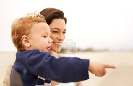 Photo for Happy mother, beach and baby pointing for fun bonding, holiday or outdoor weekend together in nature. Face of mom, little boy or toddler with smile, enjoying sightseeing or travel by the ocean coast. - Royalty Free Image
