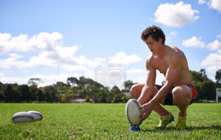 Hombre, pelota de rugby y listo para patear en la hierba con el pensamiento, objetivo y objetivo para el desafío, el entrenamiento y la aptitud. Atleta, persona y prepararse para los deportes, juegos y entrenamiento en el campo con visión de gol.
