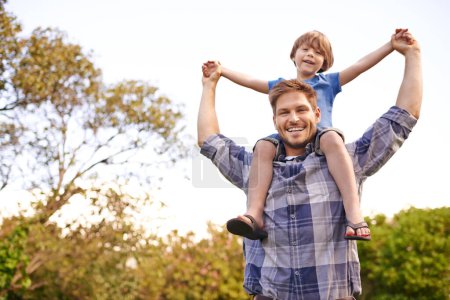Photo for Smile, nature and child on father shoulders in outdoor park or field for playing together. Happy, bonding and portrait of excited young dad carrying boy kid for fun in garden in Canada for summer - Royalty Free Image