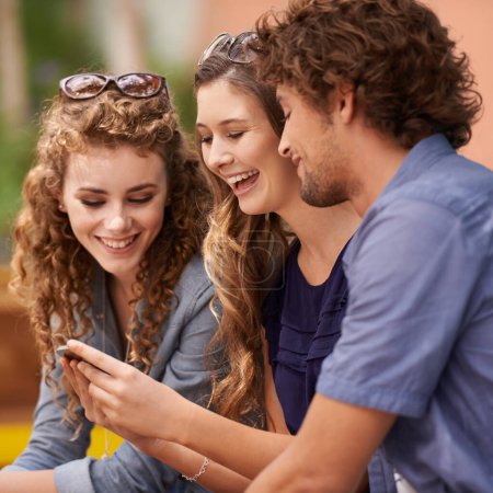 Friends, laughing and talking with cellphone for social media, internet and text. Young people, conversation and humor with tech for online and scrolling for memes, comedy and laughter with app.