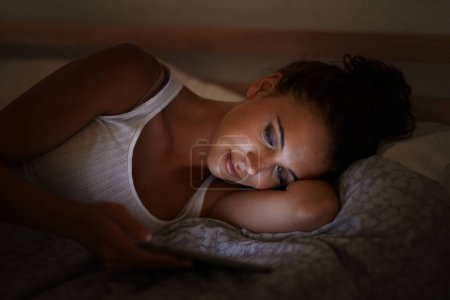 Photo for Female person, tablet and bed at night, scrolling and entertainment with tech and relaxing for peace before sleep. Woman, browsing and online for home, internet and ebook or social media. - Royalty Free Image