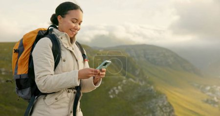 Photo for Woman hiking and travel on mountains with phone for social media update, location search and outdoor internet. Young influencer with backpack and mobile app for trekking results or progress on a hill. - Royalty Free Image