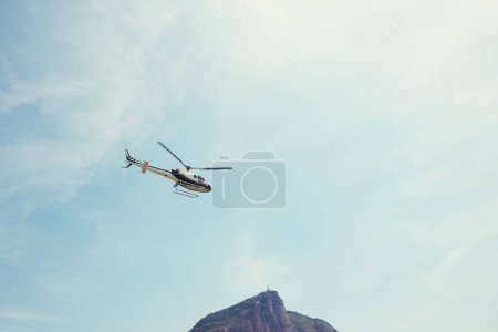 Photo for Drone, view and helicopter in a blue sky for travel, adventure or low angle transportation. Flying, freedom or aircraft in nature for search and rescue, cargo or emergency, service and assistance. - Royalty Free Image