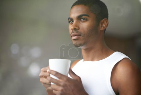 Foto de Hombre negro, pensando y por la mañana con café para el desayuno o la ambición sobre fondo bokeh en casa. Rostro de una persona joven africana o masculina maravillada, pensada o relajada con taza, taza o té en casa. - Imagen libre de derechos
