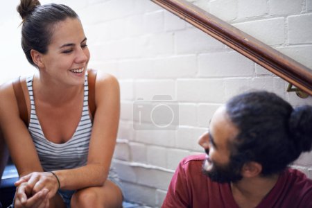 Photo for Campus, woman and man together on stairs with smile, backpack and classmates as friends. University, school and people in course for education with scholarship, laughing and conversation to relax. - Royalty Free Image