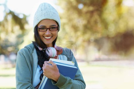 Photo for Portrait, student and woman in park with books for studying, learning and reading outdoors. Education, happy and person with bag, textbooks and headphones relax for university, campus or college. - Royalty Free Image