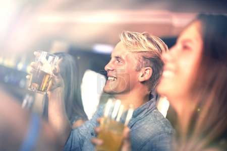 Téléchargez les photos : Sourire, l'homme et boire de la bière avec des amis au pub à la fête pour la célébration ensemble au restaurant pour se détendre pour les loisirs dans le club. Heureux, groupe ou personnes avec de l'alcool dans le verre au bar pour le rassemblement social. - en image libre de droit
