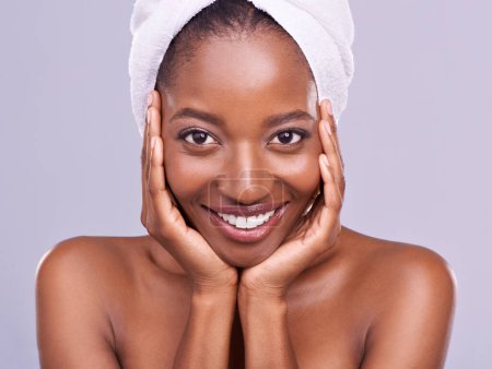 Haare, Handtuch und Porträt einer schwarzen Frau im Studio für Hautpflege, Wellness oder Körperpflege auf violettem Hintergrund. Schönheit, Reinigung und Hände auf dem Gesicht des afrikanischen weiblichen Modells mit Kosmetik, Glanz oder Glühen.