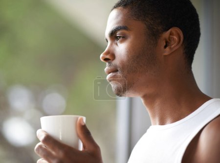 Foto de Hombre negro, ventana y pensando con café para soñar, empezar o mañana en ambición o visión en casa. Rostro de hombre africano maravillado o pensado con taza o taza de té para desayunar en casa. - Imagen libre de derechos