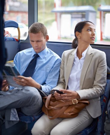 Photo for Business people, man and woman on bus for public transport, newspaper and smartphone for urban commute. Professional, colleagues and coworkers in transit or traveling to work in formal clothes. - Royalty Free Image