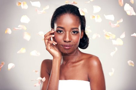 Photo for Portrait, beauty and petals with serious black woman in studio on pink background for wellness. Face, skincare and cosmetics with natural young aesthetic model at spa for dermatology treatment. - Royalty Free Image