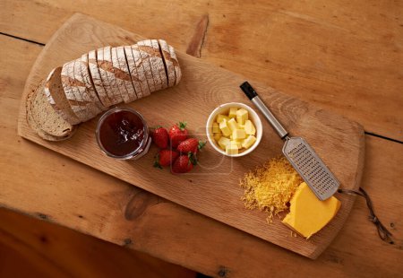 Photo for Breakfast, board and cheese with jam, bread and fresh strawberry for diet, nutrition and gourmet morning snack. Food, fruit and high angle of sweet, savory and delicious rustic brunch on charcuterie - Royalty Free Image