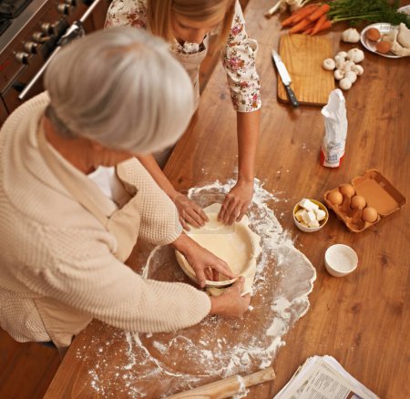 Téléchargez les photos : Grand-mère, petite-fille et ensemble à la maison pour cuire une tarte maison sans gluten, coller et apprendre la recette de grand-mère. Personne âgée, petit-enfant et ingrédients à préparer avec amour de famille d'en haut. - en image libre de droit