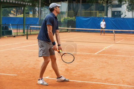 Photo for Tennis, serve and man in game of sport, competition or exercise for fitness on court. Athlete, workout and play on pitch outdoor in summer with action, challenge and person start contest with ball. - Royalty Free Image