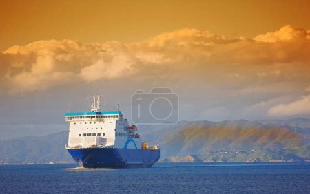 Photo for Ship, ocean and mountain at sunset to travel with clouds, water and transportation for vacation sailing. Cruise, sky and sea with yacht for tourism, holiday and adventure with sunrise, trip or nature. - Royalty Free Image