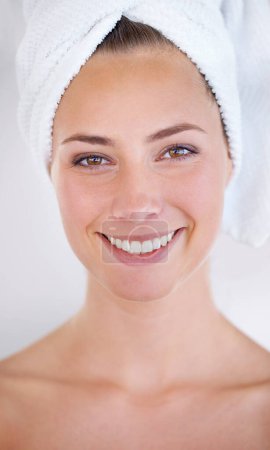 Photo for Woman, face and smile with towel for skincare, dermatology, and cosmetic treatment for beauty. Model, happy person and clear skin for hygiene and cleanse for natural and fresh with bright smile. - Royalty Free Image