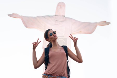 Foto de Jesús, mujer o turista de vacaciones con estatua para viajar o fe cristiana con arte o signo de paz. Monumento de persona, vacaciones o historia para el turismo, Dios o la religión símbolo en Río de Janeiro, Brasil. - Imagen libre de derechos