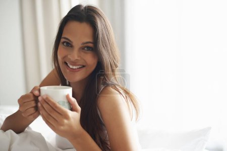 Photo for Smile, portrait and woman with coffee in bedroom with caffeine to wake up in morning at home. Happy, relax and comfy young female person drinking mug of cappuccino, espresso or latte in apartment - Royalty Free Image