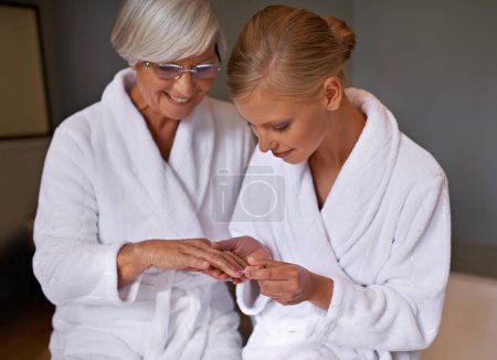 Photo for Senior mother, woman and manicure at home, cosmetics and spa for bonding and relaxation. Parent, daughter and nail polish with bath, guidance and support with beauty treatment or makeup with robe. - Royalty Free Image