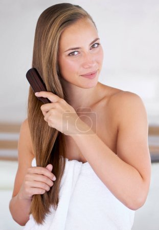 Photo for Portrait, brush and hair care of woman in bathroom in home for cosmetics, cleaning and wellness for health. Hairstyle, face or person in towel combing for morning routine, beauty or keratin treatment. - Royalty Free Image