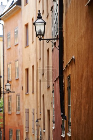 Photo for Travel, architecture and lamp in vintage alley of old town with history, culture or holiday destination in Sweden. Vacation, buildings and antique lantern in Stockholm with retro light ancient city. - Royalty Free Image