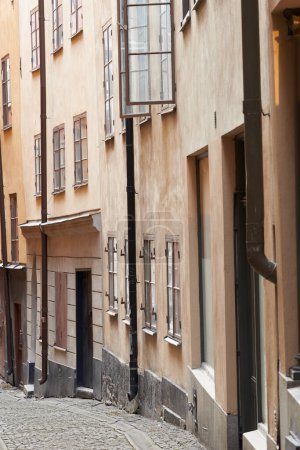 Photo for Travel, architecture and alley in vintage town with history, culture or holiday destination in Sweden. Vacation, old buildings and antique street in Stockholm with retro cobble road in ancient city. - Royalty Free Image