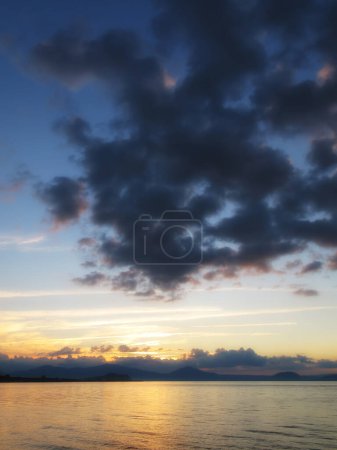 Photo for Ocean, sunset and clouds in sky with mountains, water and seaside in evening. New Zealand, travel and destination for vacation in summer island, landscape and environment for holiday with nature. - Royalty Free Image