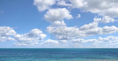 Téléchargez les photos : Ciel bleu, océan et nuages avec fond d'horizon pour la paix, la nature et l'environnement avec paysage marin skyline de plage tropicale. Eau calme, mer et terre avec emplacement pour une pause ou des vacances avec vue. - en image libre de droit