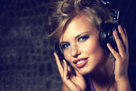 Photo for Happy, portrait and woman with headphones for music, streaming and listening to radio in dark. Techno, sound and face of musician mixing track and relax with trippy audio for entertainment in home. - Royalty Free Image