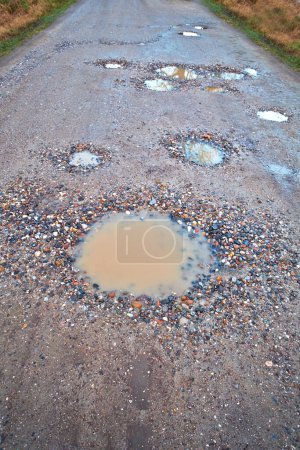 Photo for Water, gravel and rural road with pothole with maintenance, infrastructure and farm transport in winter. Dirt, path and rain puddle in hole on countryside street with damage, ground and nature - Royalty Free Image
