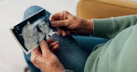Téléchargez les photos : Les mains, la photographie et les personnes âgées à la retraite avec la mémoire, se détendre avec l'histoire pour la nostalgie et penser à la vie. Souvenez-vous, passé et vieillesse avec pension, image rétro et repos dans le salon. - en image libre de droit