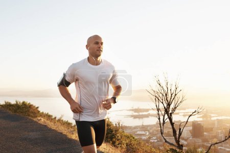 Photo for Athlete, man and running in road with music for sport, exercise and fitness for competition or marathon in nature. Runner, person and workout with wellness, seaside and earphones for cardio in Mexico. - Royalty Free Image