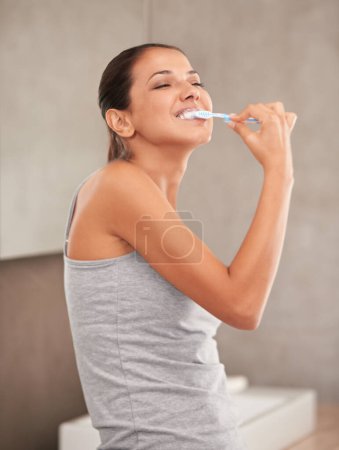 Foto de Feliz, baño y mujer con cepillo de dientes para limpieza, higiene bucal y cuidado dental en el hogar. Pasta dental, cuidado de la salud y persona cepillarse los dientes para blanquear, bienestar y aseo para la enfermedad de las encías. - Imagen libre de derechos