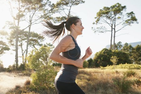 Téléchargez les photos : Exercice, course et la femme sur le chemin de la montagne pour la santé, le bien-être et le développement du corps forte. Entraînement, fitness et fille coureuse sur route dans la nature pour l'entraînement au marathon, la performance et le défi - en image libre de droit