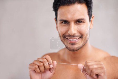 Photo for Dental, portrait and man in bathroom for flossing teeth, self care and morning routine. Oral hygiene, confidence and face of Mexican male person at home for wellness, cleaning and healthy mouth - Royalty Free Image