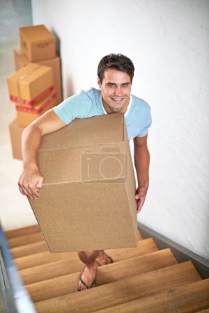 Homme, portrait et boîtes dans maison neuve par des escaliers avec sourire, nouveau départ et investissement dans l'immobilier. Personne, carton et forfait sur marches en appartement, maison et heureux à louer, déménagement ou propriété.