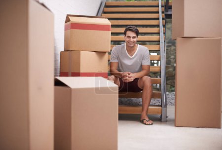 Man, moving and portrait in new house by stairs with boxes, fresh start or investment in real estate. Person, cardboard and package on steps in apartment, home or happy for rent, mortgage or property.