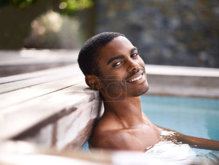 Téléchargez les photos : Portrait, piscine et eau avec l'homme africain souriant, vacances et vacances en plein air pour se détendre au soleil. Été, baignade et bonheur pour le bien-être du corps, personne calme et divertissement week-end. - en image libre de droit