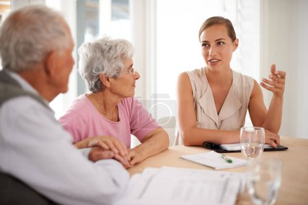 Senioren-, Paar- oder Finanzberater mit Diskussion über Versicherungen, Altersvorsorge oder Vertragsunterlagen nach Tabelle. Ältere Menschen, Personen oder Berater mit Formalitäten für eine Eigentumsurkunde oder einen Rentenvertrag.