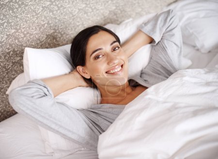 Photo for Woman, smile and bed for portrait, sleep and comfort in home, indoor and alone on weekend. Young person, happy and pillow for wake up in pajamas for relax, rest or refreshed on mattress with blanket. - Royalty Free Image